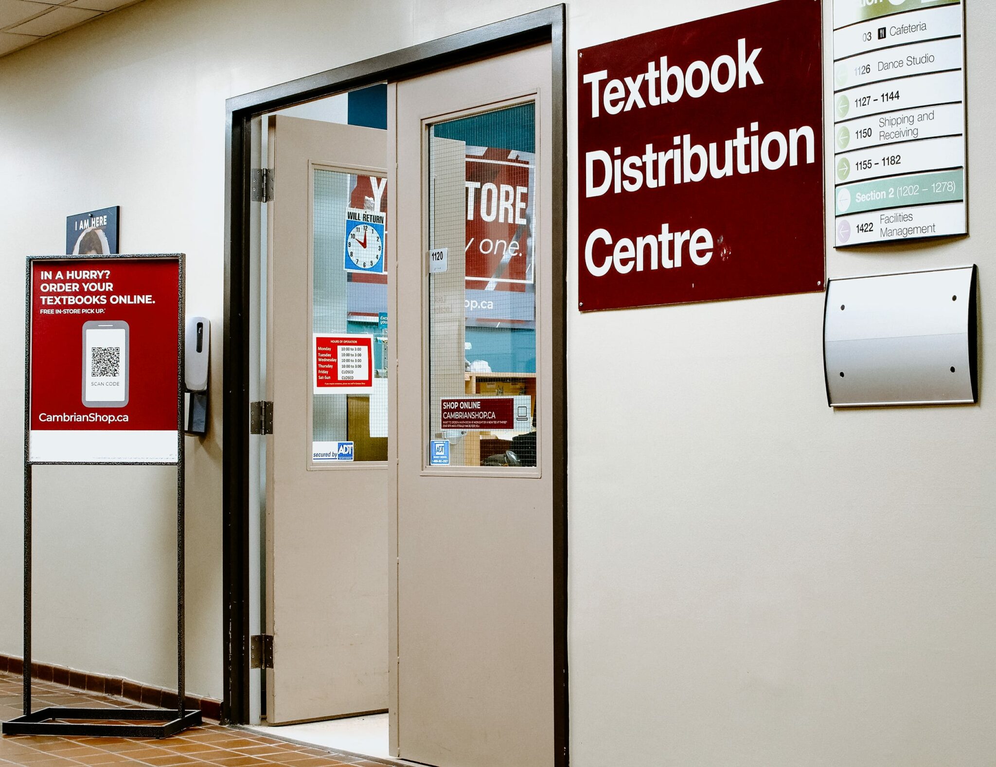 Entrance to Cambrian's Textbook Distribution Centre with signs and a door, located in a hallway.