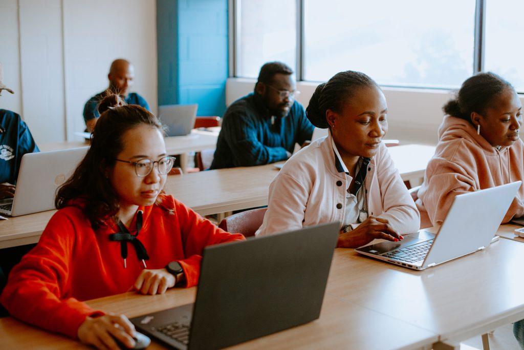Multiple students on laptops in a classroom