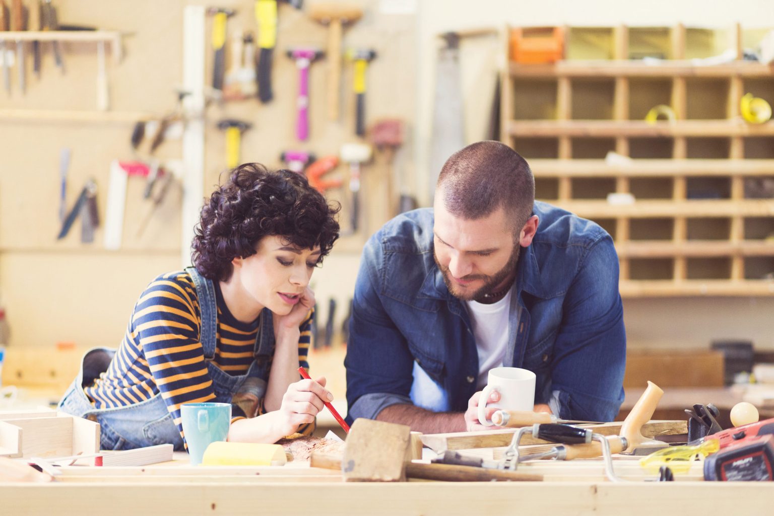 A man and a woman in a workshop working together.