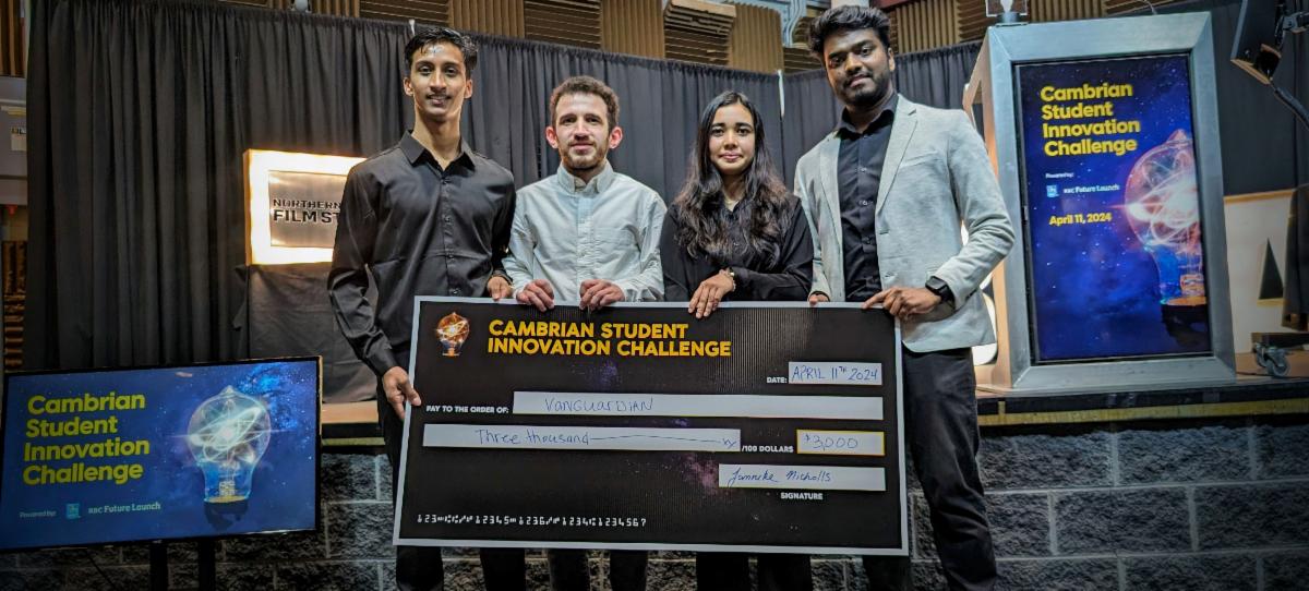 Four people stand holding a large $3,000 check from RBC at the Cambrian Student Innovation Challenge, with event signage visible in the background.