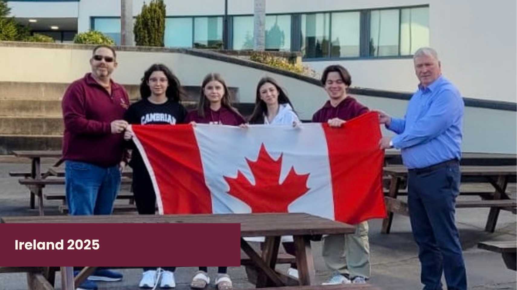 Six people stand outdoors holding a Canadian flag, with buildings in the background. Text in the corner reads "Ireland 2025." This moment captures participants from Cambrian College Global Skills Opportunity.